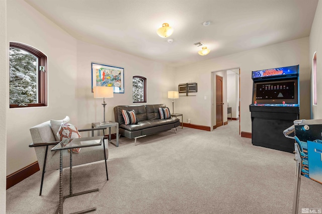 living area featuring plenty of natural light, visible vents, baseboards, and carpet