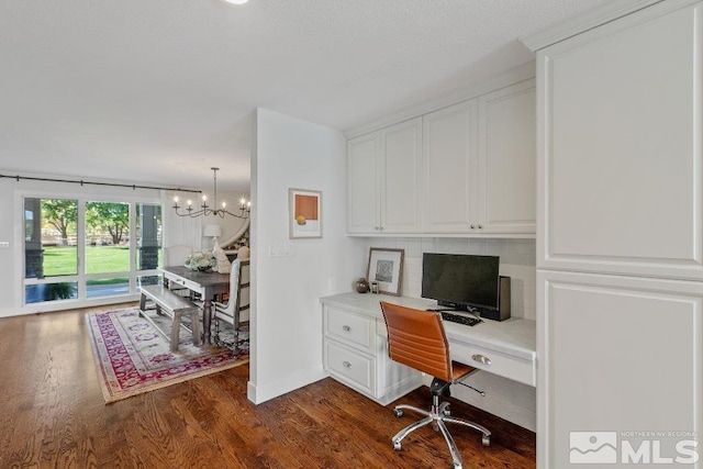 office space with baseboards, an inviting chandelier, and dark wood-style flooring