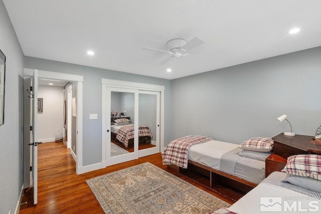 bedroom featuring baseboards, recessed lighting, wood finished floors, a closet, and a ceiling fan