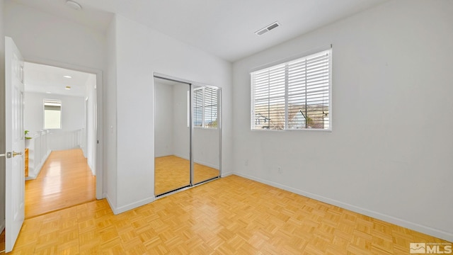 unfurnished bedroom with baseboards, visible vents, and a closet