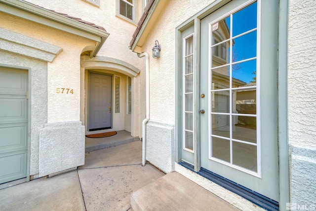 doorway to property featuring stucco siding and a garage