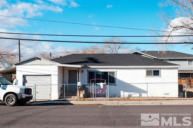 ranch-style home featuring a fenced front yard and an attached garage