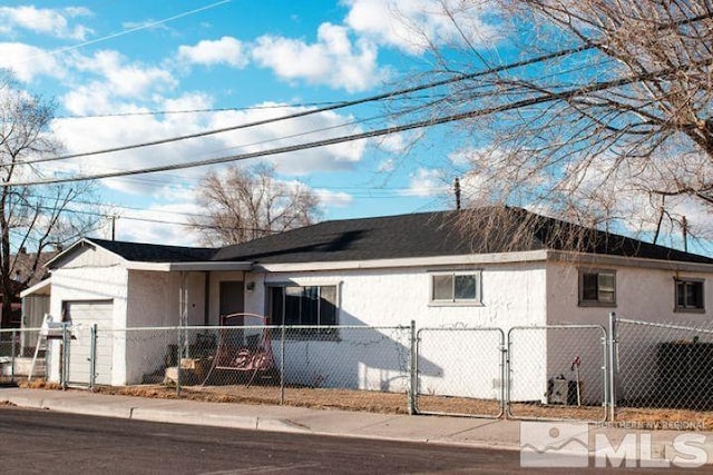 view of front of home with a fenced front yard, stucco siding, and a gate