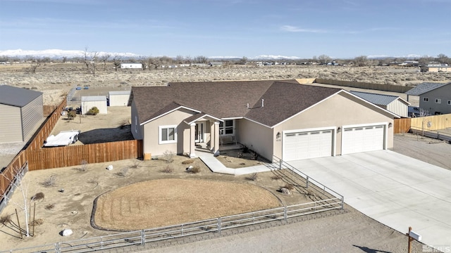 ranch-style home featuring stucco siding, concrete driveway, a garage, and fence