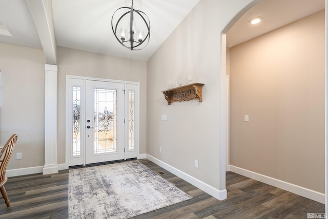 foyer entrance with baseboards, arched walkways, and dark wood-style flooring