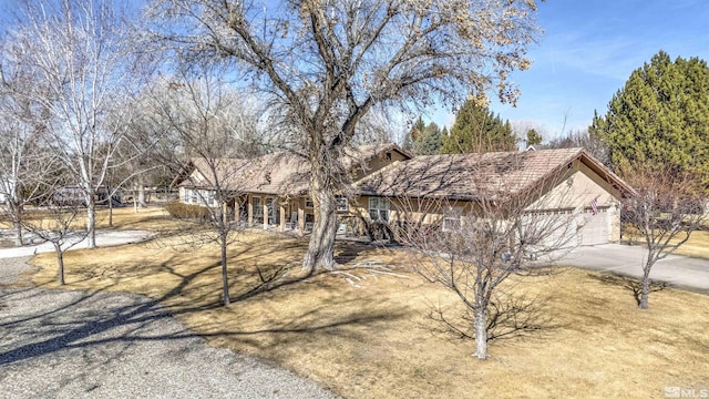 view of front of home with a garage, driveway, and stucco siding