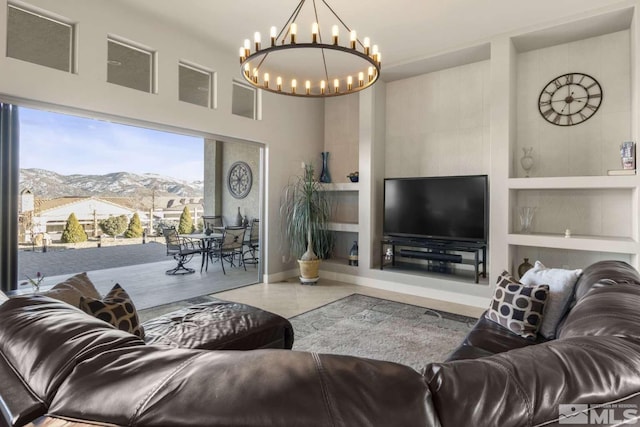 tiled living area featuring baseboards, built in shelves, a high ceiling, and a chandelier