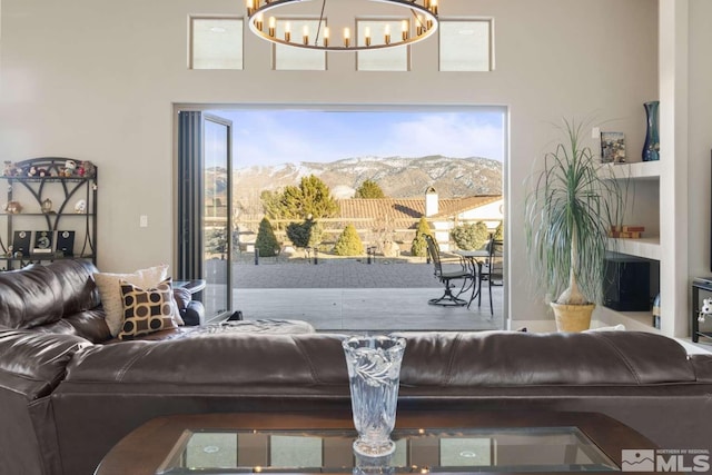 living area with a notable chandelier, a mountain view, and built in shelves