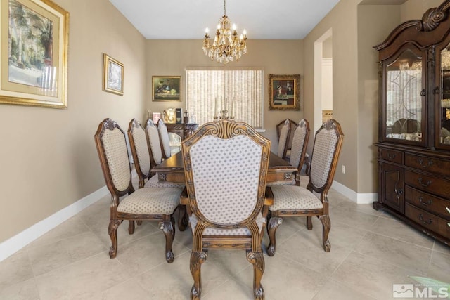 dining room featuring light tile patterned floors, baseboards, and a notable chandelier