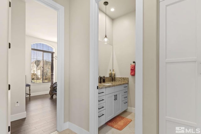 bathroom featuring vanity, recessed lighting, wood finished floors, and baseboards