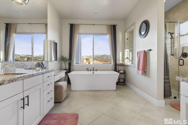 full bath with vanity, baseboards, a freestanding bath, tile patterned flooring, and a shower stall