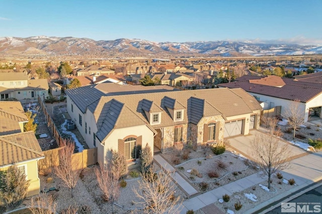 view of front facade with a residential view, stucco siding, a garage, stone siding, and driveway