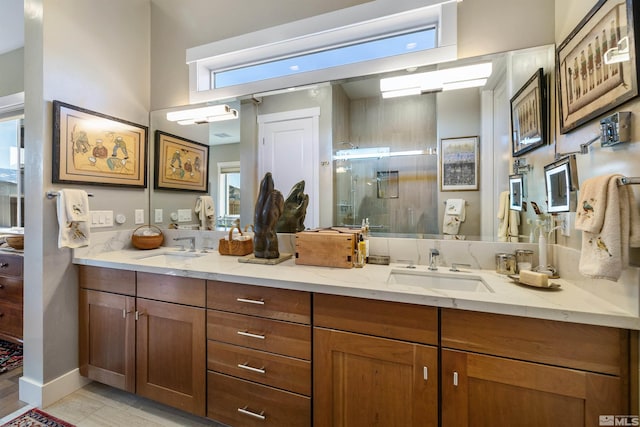 bathroom featuring double vanity, a stall shower, and a sink