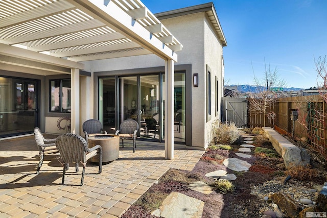 view of patio / terrace featuring a gate, fence, a pergola, and an outdoor fire pit