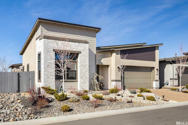 modern home featuring stucco siding, driveway, and fence