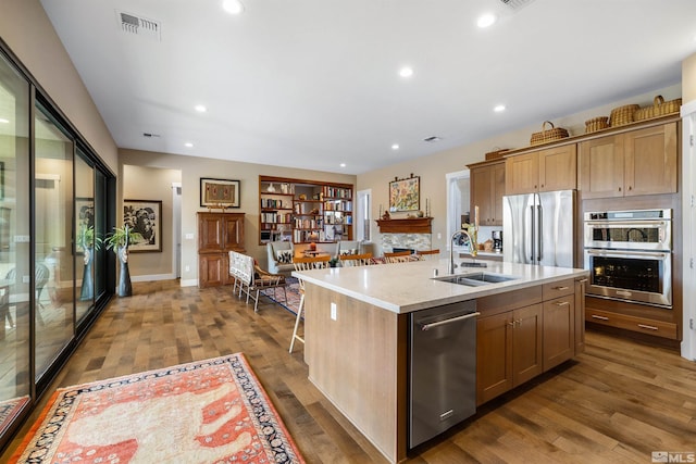 kitchen featuring visible vents, recessed lighting, dark wood-style floors, stainless steel appliances, and a sink