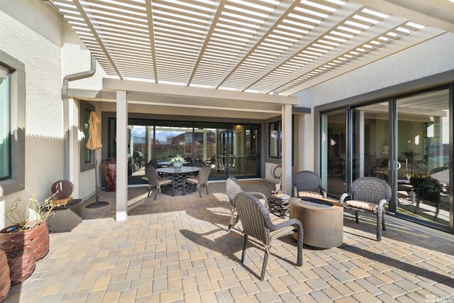 view of patio with a fire pit, outdoor dining space, and a pergola