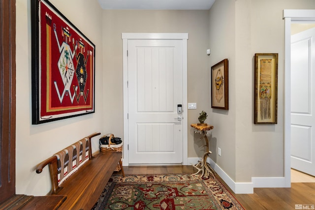 foyer featuring baseboards and wood finished floors