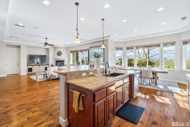 kitchen with a kitchen island with sink, visible vents, plenty of natural light, and a sink