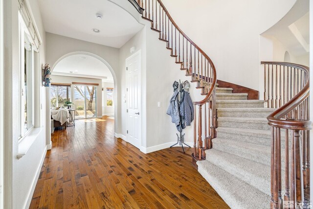 interior space with arched walkways, recessed lighting, baseboards, and wood-type flooring