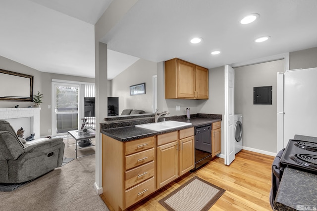 kitchen featuring black appliances, a sink, dark countertops, open floor plan, and washer / dryer