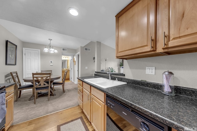 kitchen with dishwasher, dark countertops, visible vents, and a sink