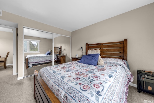 carpeted bedroom featuring a closet and baseboards