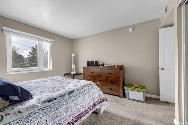 bedroom featuring light carpet, visible vents, and baseboards