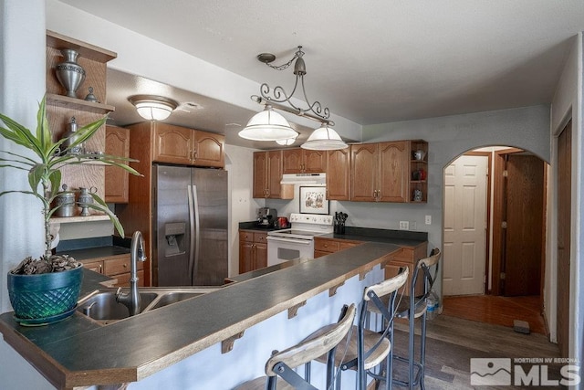 kitchen featuring open shelves, stainless steel fridge with ice dispenser, under cabinet range hood, white range with electric stovetop, and a sink