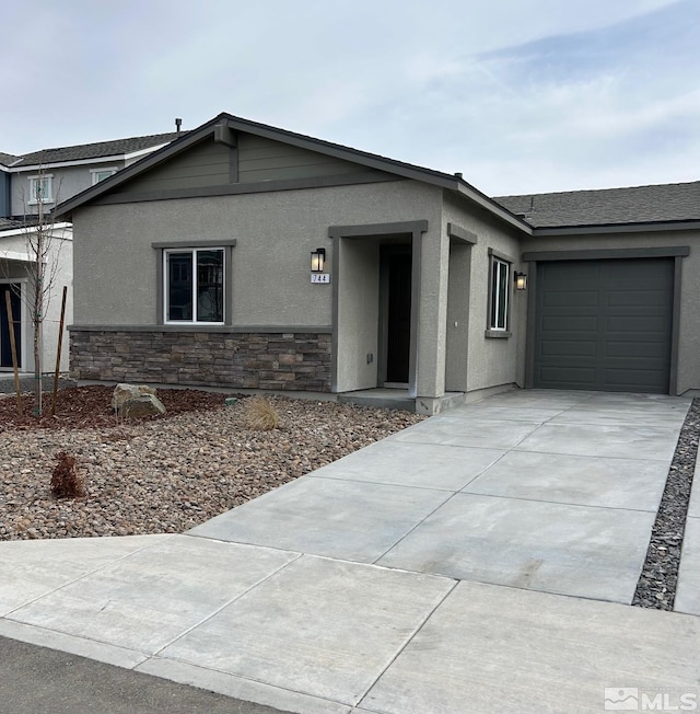 view of front of house featuring stone siding, stucco siding, driveway, and a garage