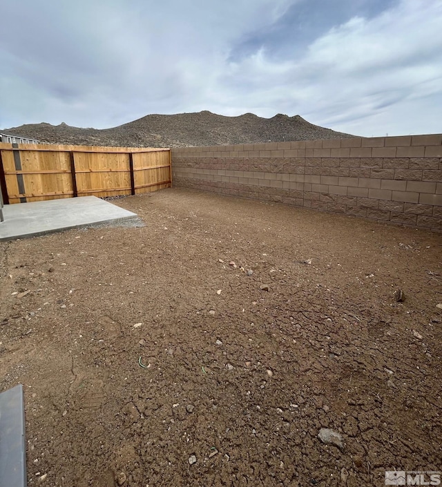 view of yard with a mountain view, a patio, and a fenced backyard