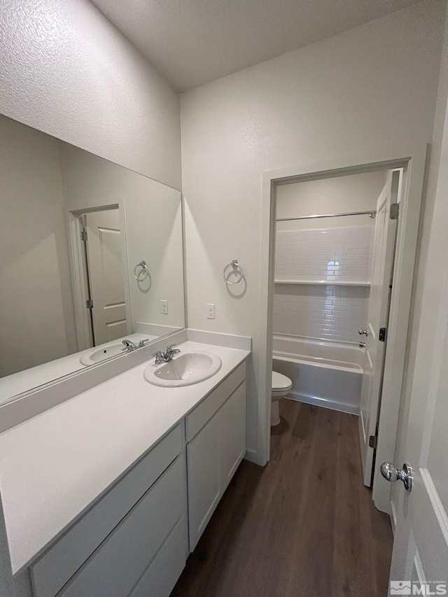 bathroom featuring bathing tub / shower combination, toilet, wood finished floors, and vanity