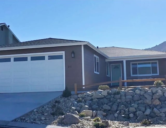 view of property exterior with a garage, roof with shingles, concrete driveway, and stucco siding