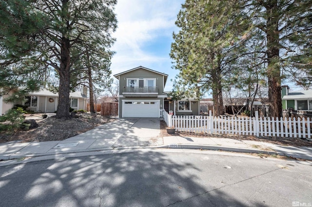 traditional-style house with a fenced front yard, a garage, and concrete driveway