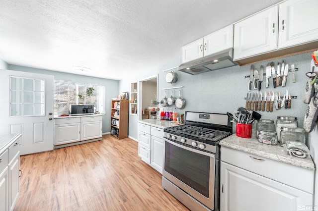 kitchen with white cabinetry, light wood finished floors, stainless steel range with gas stovetop, and under cabinet range hood