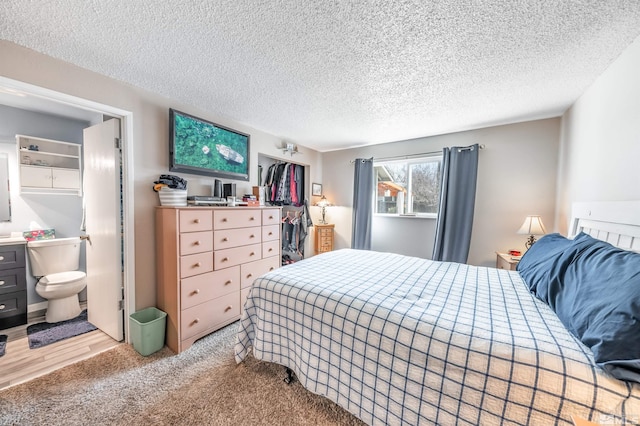 bedroom featuring light carpet and a textured ceiling