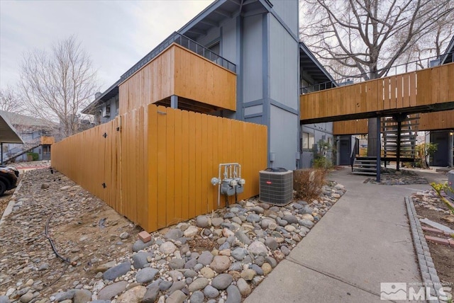 view of home's exterior with stairway and central air condition unit