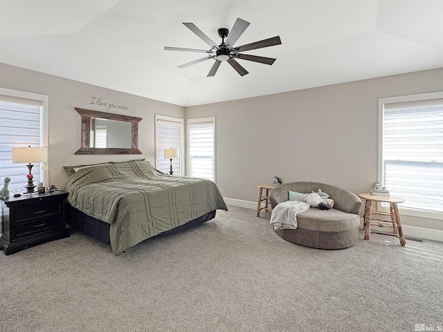 carpeted bedroom with ceiling fan, a tray ceiling, baseboards, and lofted ceiling