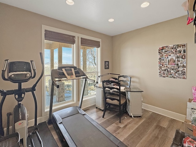 workout room featuring recessed lighting, baseboards, and wood finished floors