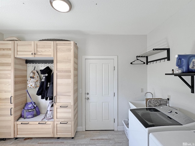 laundry area with wood finish floors, a sink, and washer and clothes dryer