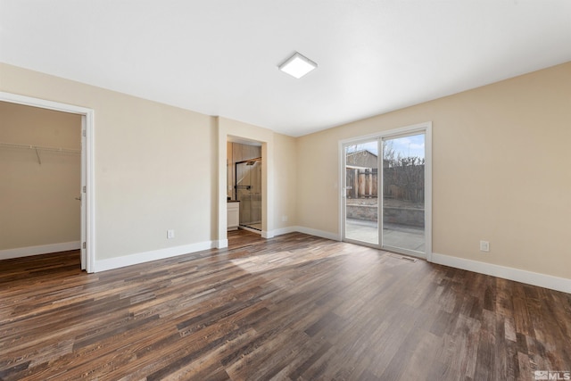 spare room with dark wood finished floors and baseboards