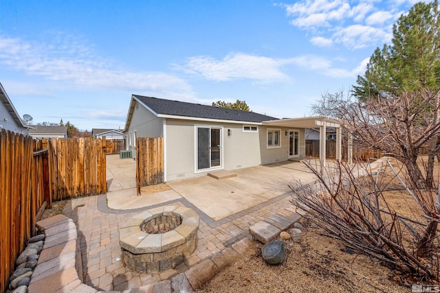 rear view of property with a fire pit, a patio area, fence, and crawl space