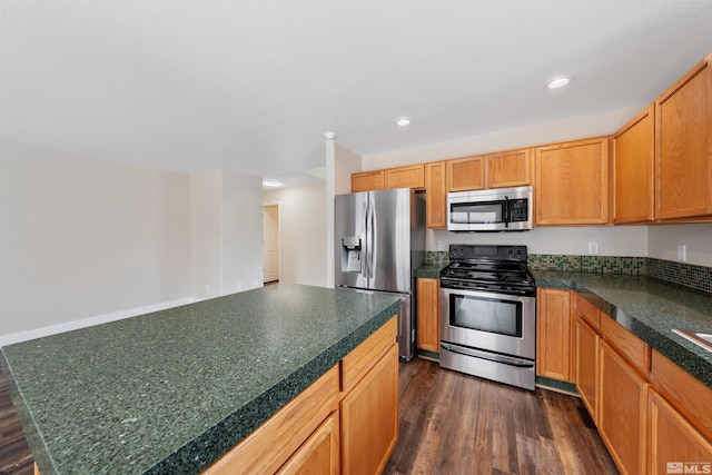 kitchen featuring tile countertops, stainless steel appliances, dark wood-type flooring, and recessed lighting