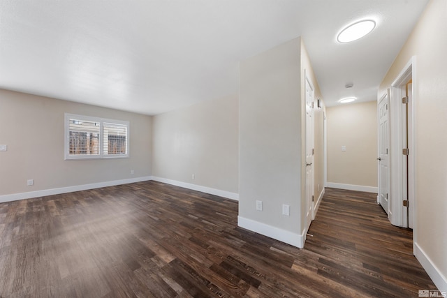 empty room with baseboards and dark wood finished floors