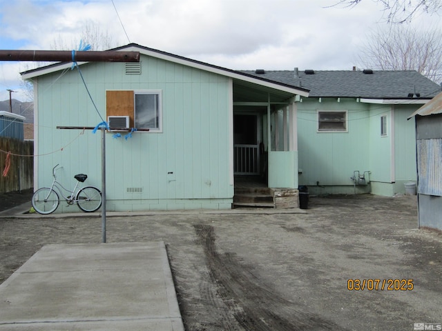 rear view of property with crawl space and roof with shingles