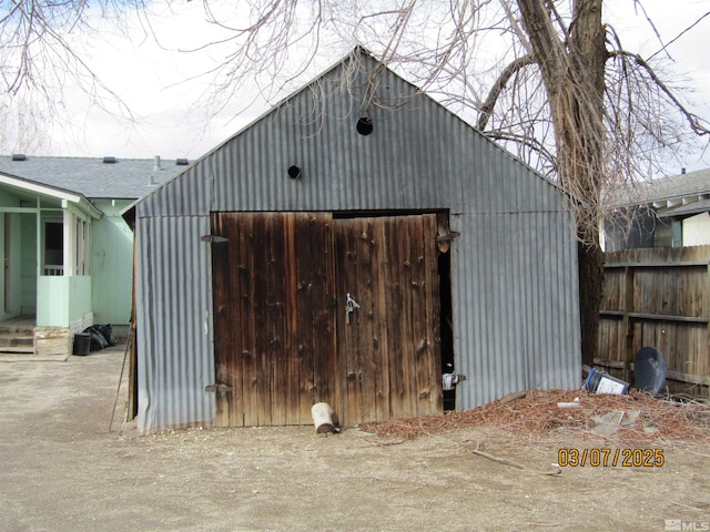 view of outdoor structure featuring an outbuilding and fence