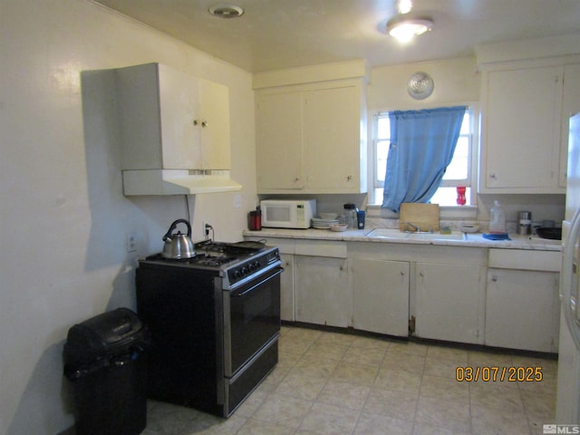 kitchen with white microwave, under cabinet range hood, light countertops, black range with gas cooktop, and white cabinetry