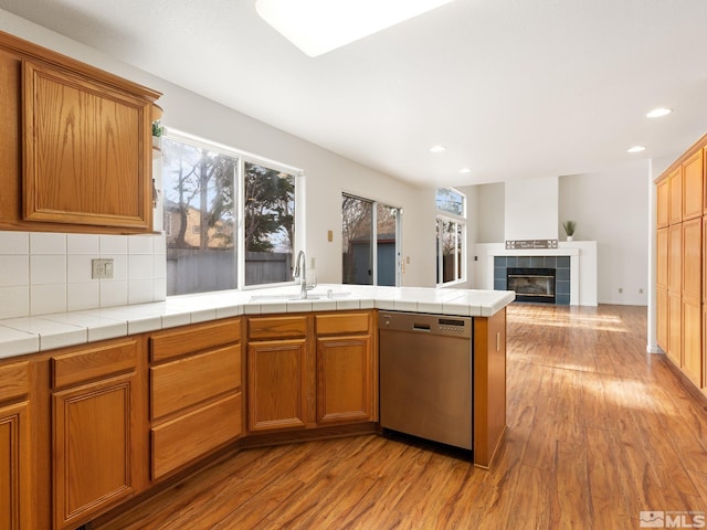 kitchen featuring dishwasher, plenty of natural light, wood finished floors, and a sink