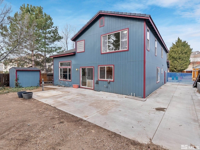 back of house featuring an outbuilding, a shed, a patio, and fence