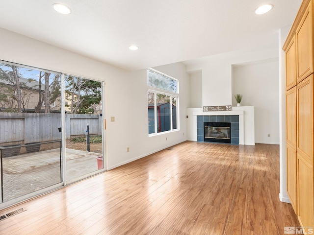 unfurnished living room featuring visible vents, baseboards, recessed lighting, a fireplace, and light wood-style floors